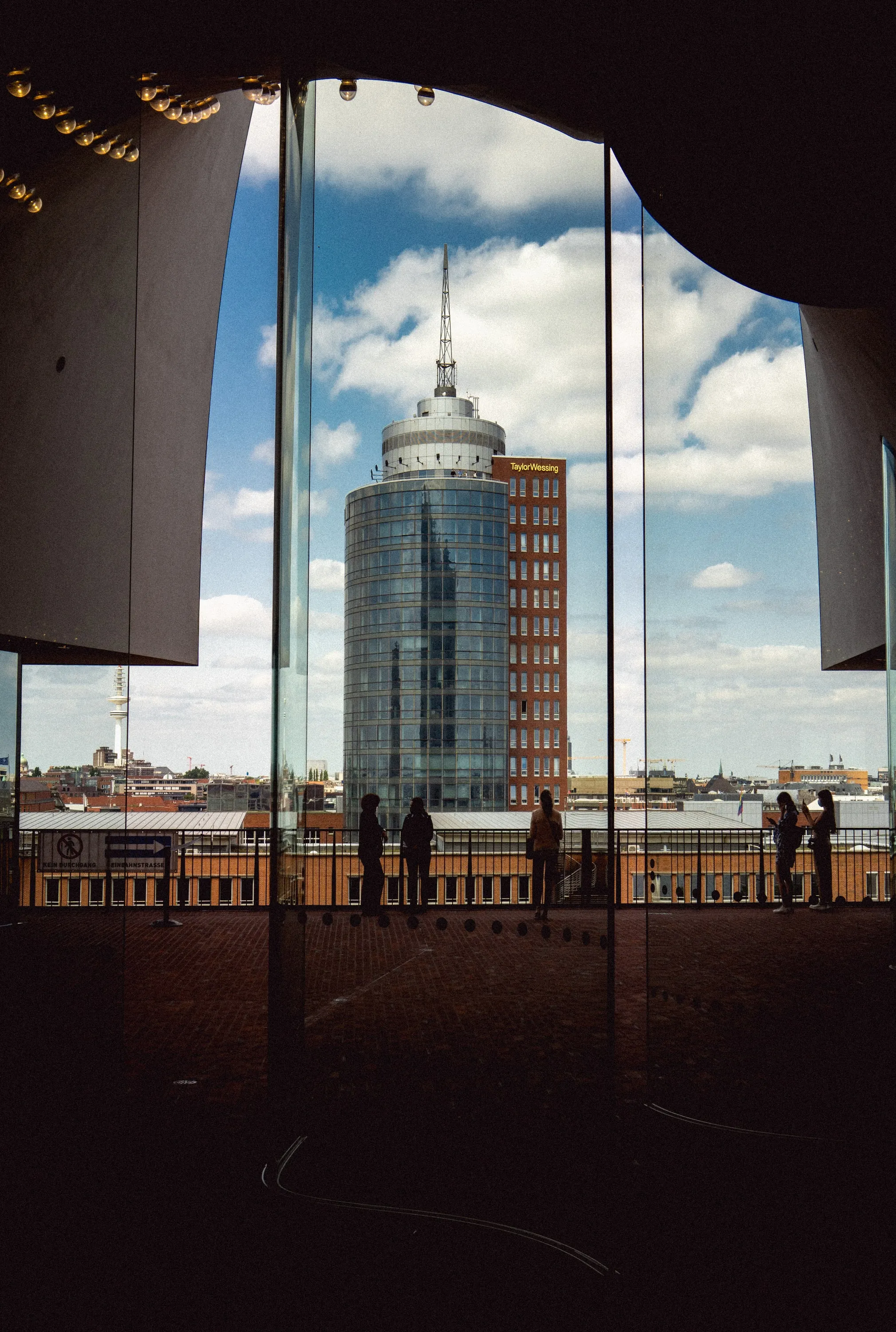 A tower block and waterfront seen through a large architectural opening.
